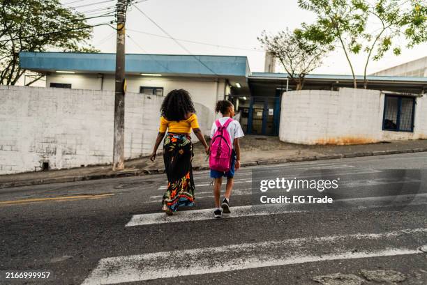 mother and schoolgirl daughter walking going to school - passadeira via pública imagens e fotografias de stock
