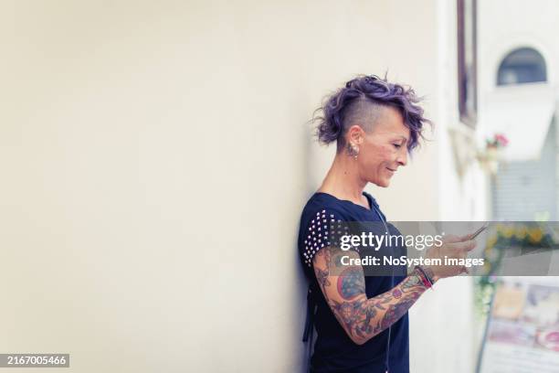 modern woman with tattoos texting outdoors - punk studs stock pictures, royalty-free photos & images