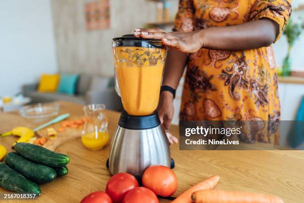 mujer embarazada haciendo un batido de frutas saludable en la licuadora - licuadora fotografías e imágenes de stock