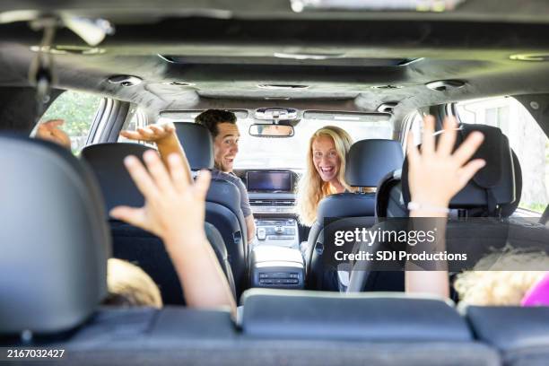 parents smile at their unrecognizable children - sports utility vehicle stock pictures, royalty-free photos & images