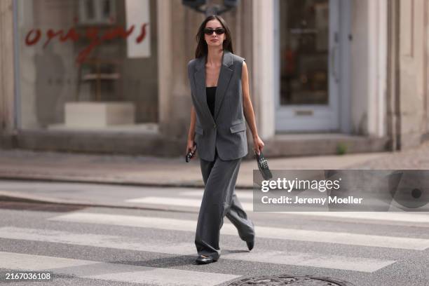 Lara von Preysing is seen wearing black sunglasses, a grey pinstriped oversized vest with shoulder pads from Gestuz, matching suit pants also from...