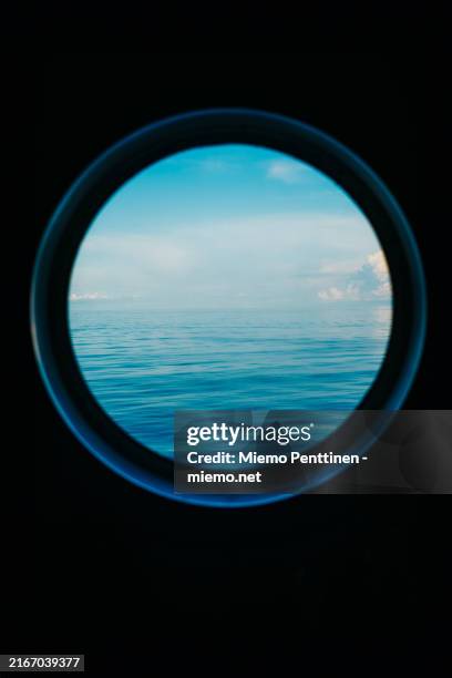 calm baltic sea seen through a circular cabin window on passenger ferry between estonia and finland - bullauge stock-fotos und bilder