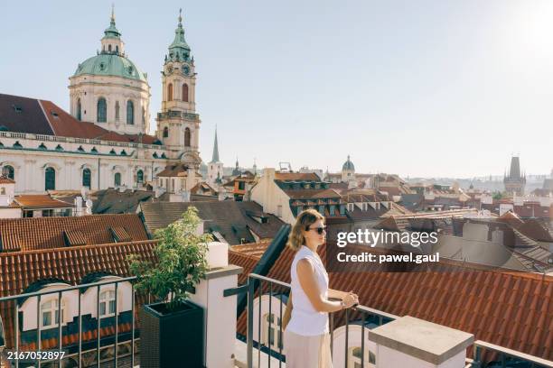mujer que observa el amanecer desde la azotea del edificio en praga, república checa - praga fotografías e imágenes de stock