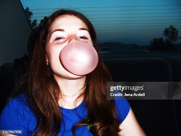 playful woman blowing bubble gum bubble, happy woman portrait - kontrastreich stock-fotos und bilder