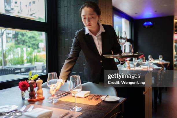 waiter placing wine glasses - upper class stock pictures, royalty-free photos & images