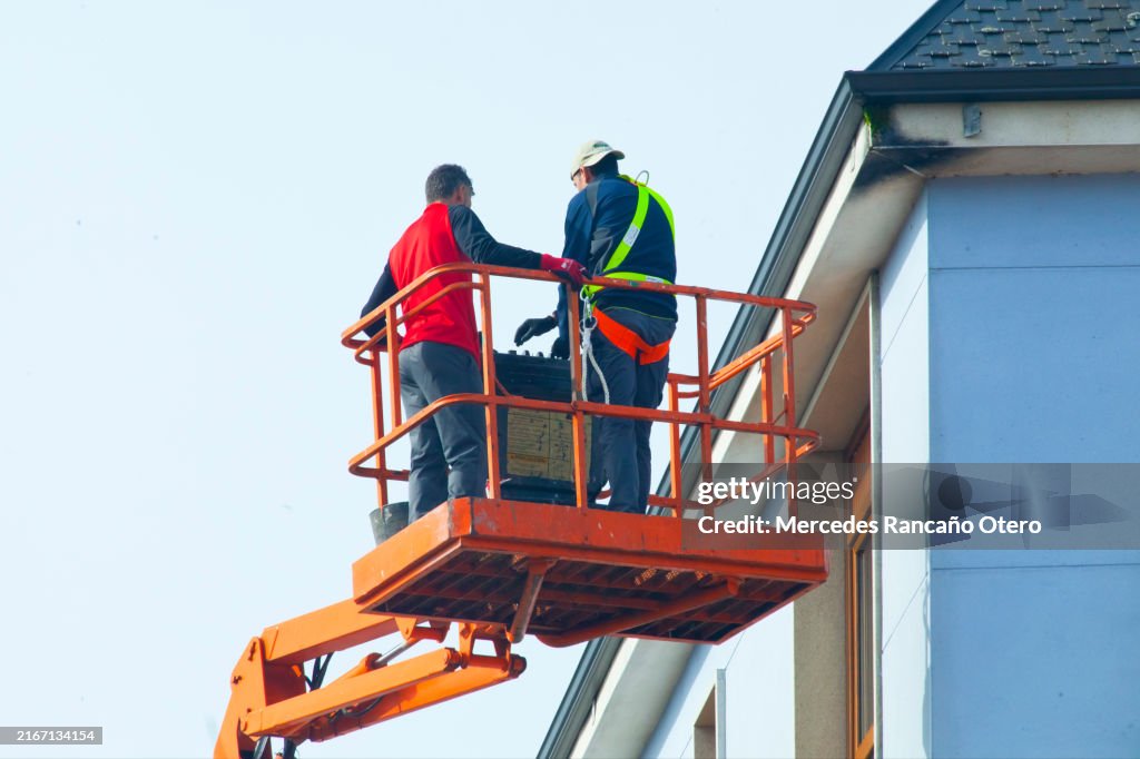 Trabajadores en una grúa. Equipo de seguridad
