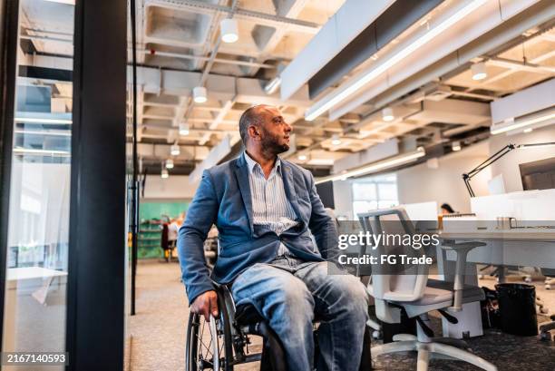 hombre de negocios en silla de ruedas caminando en la oficina - acceso para sillas de ruedas fotografías e imágenes de stock