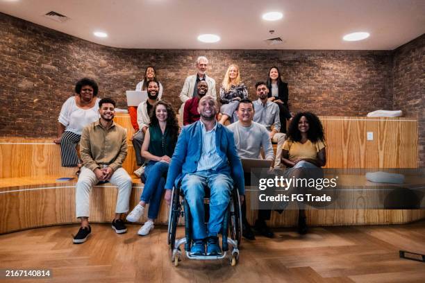 portrait of a businessman and coworkers during presentation at office - inclusion sociale photos et images de collection