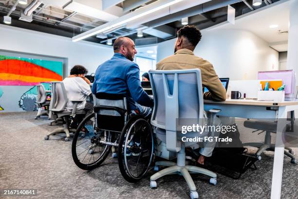 coworkers talking during meeting at office - acesso para deficientes imagens e fotografias de stock