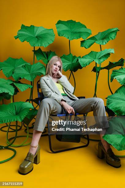 stylish woman wearing green suit - übergroße handtasche stock-fotos und bilder