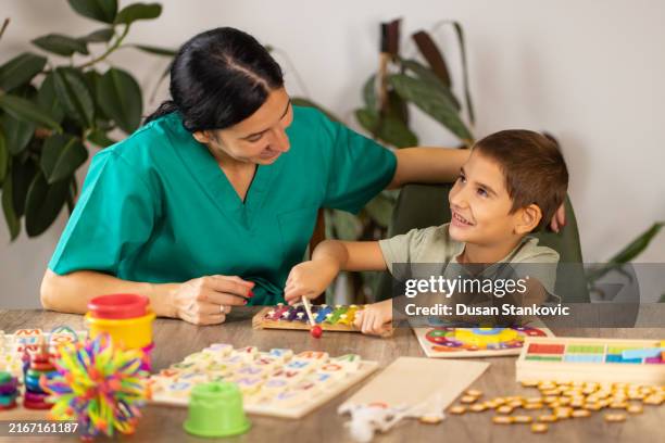 nurse engaging boy with autism in sensory play - music therapy stock pictures, royalty-free photos & images