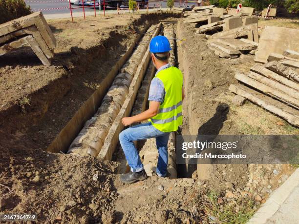 reparación de una antigua tubería de calefacción urbana en una zanja de hormigón - excavar fotografías e imágenes de stock