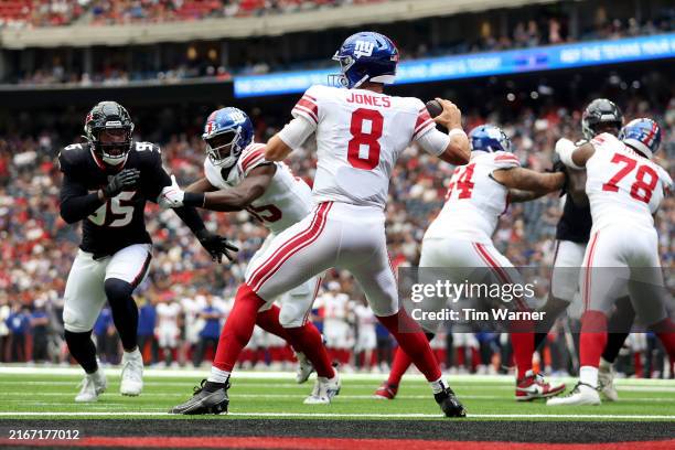 Daniel Jones of the New York Giants looks to pass under pressure by Derek Barnett of the Houston Texans in the first quarter during the preseason...