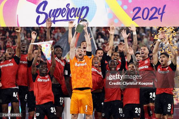 Lukas Hradecky of Bayer 04 Leverkusen lifts the DFL Supercup Trophy after his team's victory in the DFL Supercup 2024 match between Bayer 04...