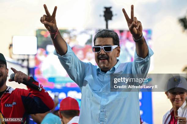 Incumbent President of Venezuela Nicolas Maduro raises his arms and make a “v” with his hands during the 'Gran Marcha Mundial por la Paz' supporting...