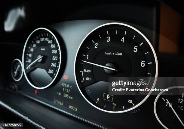 close-up of a car dashboard with speedometer and tachometer in focus. - kilometer stock-fotos und bilder