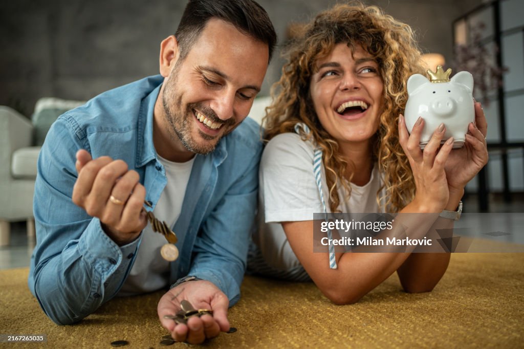 Jeune couple heureux économisant de l’argent pour leur prochain investissement, shopping ou vacances