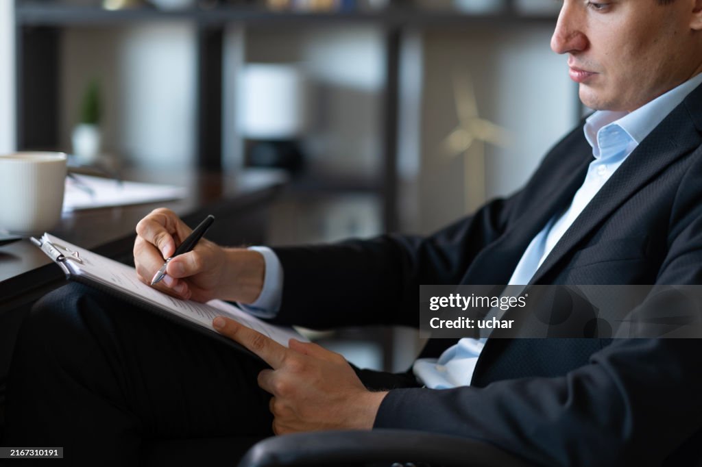 Handsome young businessman preparing official documents in the office