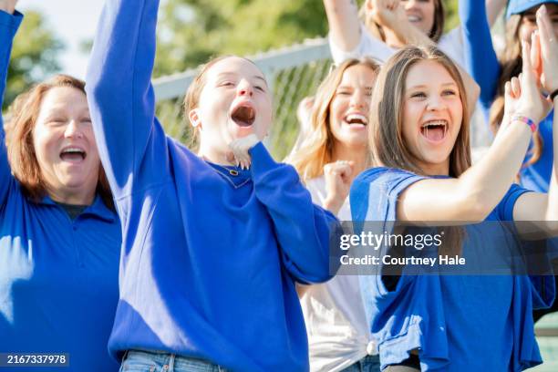 Group of excited sports fans cheer on their favorite football team