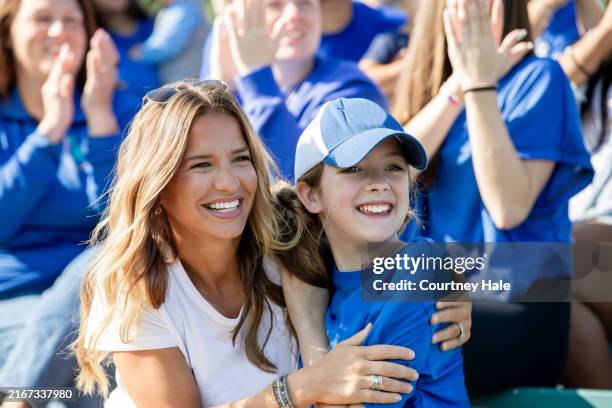 mom and daughter hug while cheering on their favorite college football team - girl football fan stock pictures, royalty-free photos & images