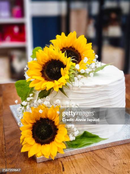 white wedding cake decorated with sunflowers, front view - wedding reception flowers stock pictures, royalty-free photos & images