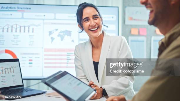 lächelnde geschäftsfrau, die mit entwicklern diskutiert, trifft sich, um die datenanalyse des marketings von social-media-plattformen zu überprüfen. - digitales marketing stock-fotos und bilder