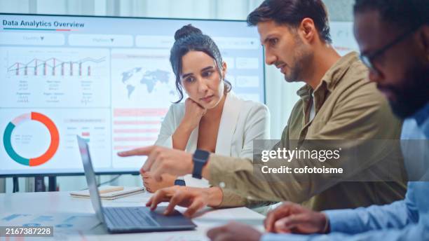 a team of multiethnic developers is meeting to discuss the data analytics of marketing. - datos fotografías e imágenes de stock