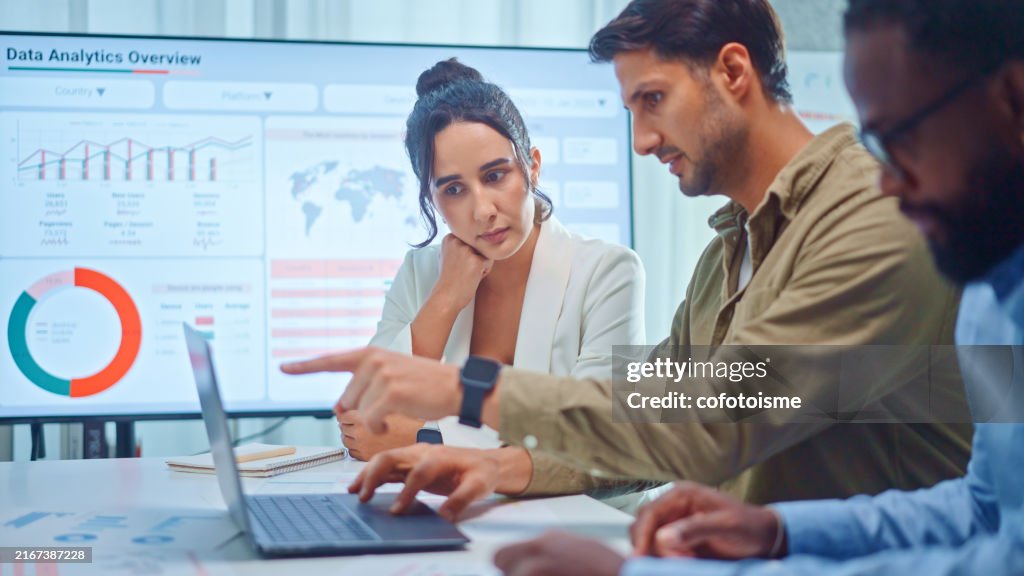 A team of multiethnic developers is meeting to discuss the data analytics of marketing.