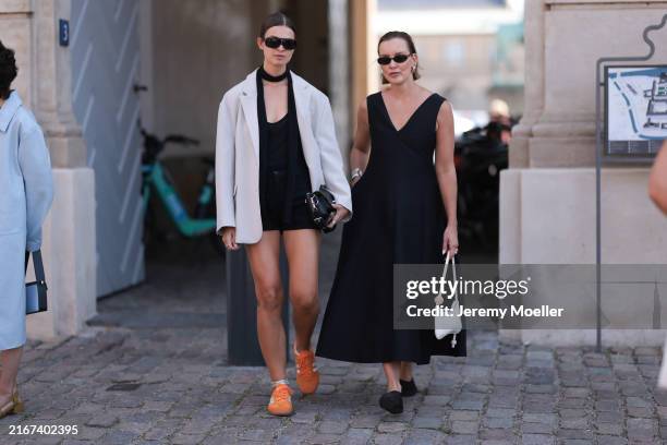 Jacqueline Zelwis is seen wearing black angular aviator sunglasses from Saint Laurent, multiple silver earrings and studs, a grey-white blazer from...