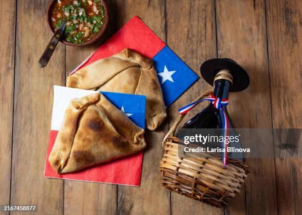 chilean independence day concept. fiestas patrias. tipical baked empanadas de pino, wine or chicha. dish and drink on 18 september party, wooden background - setembro imagens e fotografias de stock