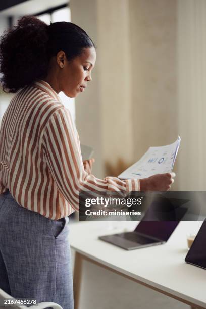 professional woman analyzing financial data in modern office setting - responsibility stock pictures, royalty-free photos & images