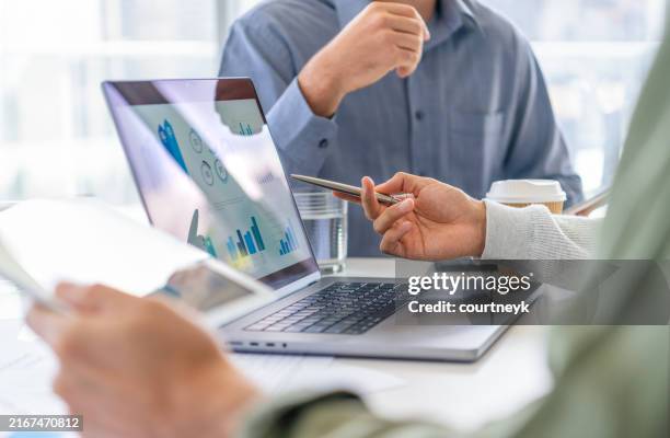 group of men working with paperwork on a board room table at a business meeting or semina - marktonderzoek stockfoto's en -beelden