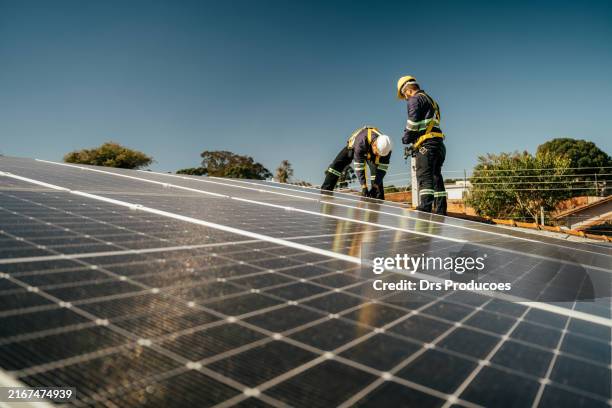 two workers installing solar panel on roof - occupation stock pictures, royalty-free photos & images