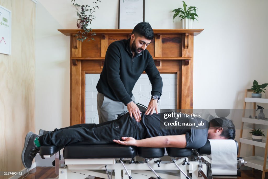 A chiropractor performing a spinal adjustment on a patient.