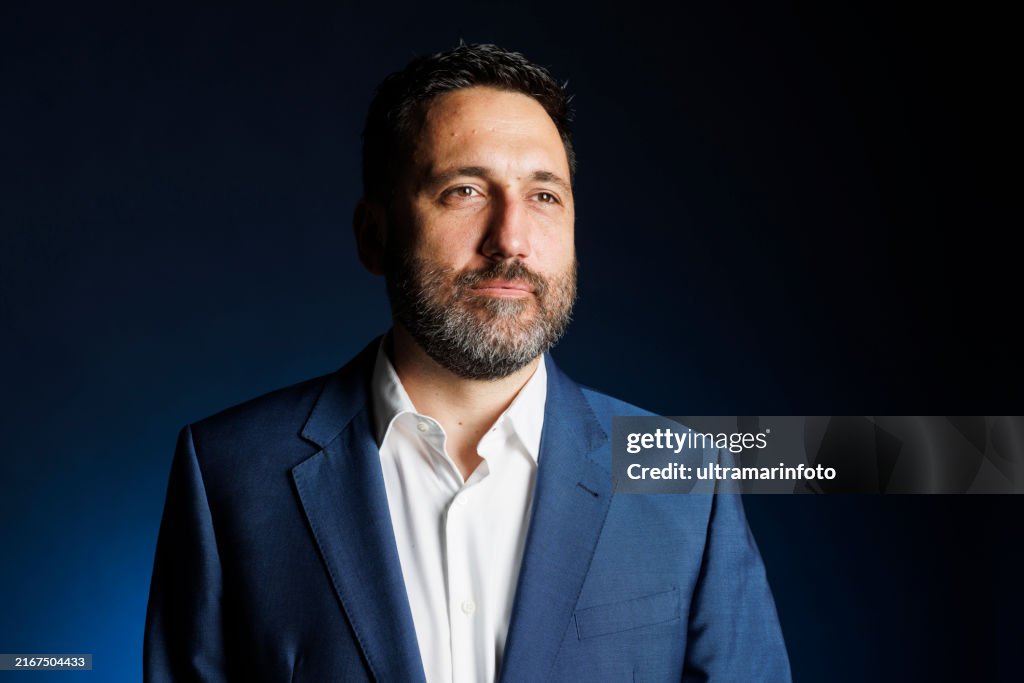 Studio portrait handsome man. Elegance Blue well-dressed businessman, Dark blue background.