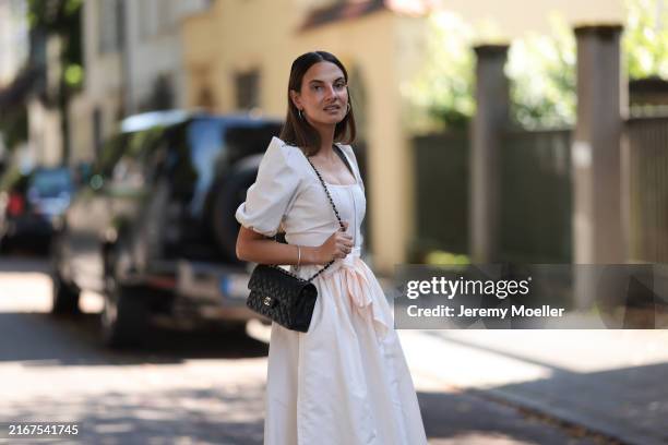 Anna Winter seen wearing silver hoop earrings, Cocovero creamy white dirndl / short dress, Chanel black leather bag, on August 15, 2024 in Munich,...