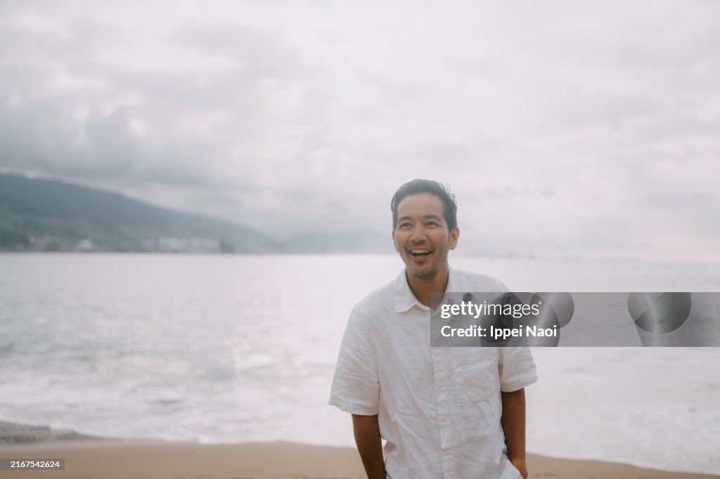 Cheerful man on walking on beach, Spain