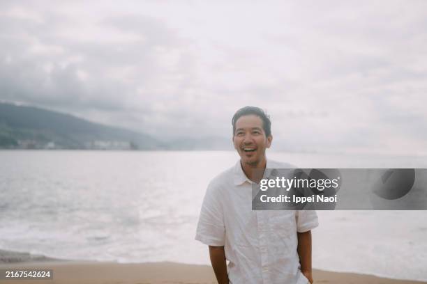 cheerful man on walking on beach, spain - solo un uomo di età media foto e immagini stock