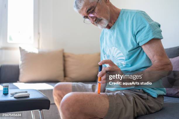 mann injektion insulin spritze in sein bein zu hause - hormontherapie stock-fotos und bilder
