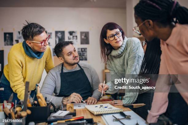 teacher explaining art concepts to students in workshop. - kunstatelier stockfoto's en -beelden