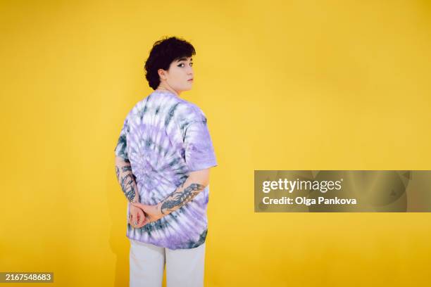 portrait of a confident young woman on a yellow background - encuadre de tres cuartos fotografías e imágenes de stock
