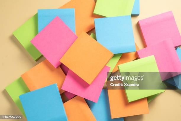 a pile of colorful sticky notes scattered on a yellow background - scattered stock pictures, royalty-free photos & images