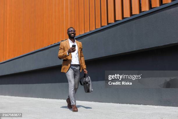stilvoller geschäftsmann in bewegung - afrikanischer abstammung stock-fotos und bilder