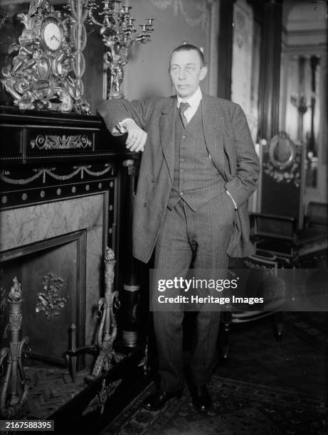 Rachmaninoff, between circa 1915 and circa 1920. Shows Sergei Vasilievich Rachmaninoff standing at a fireplace. Creator: Bain News Service.