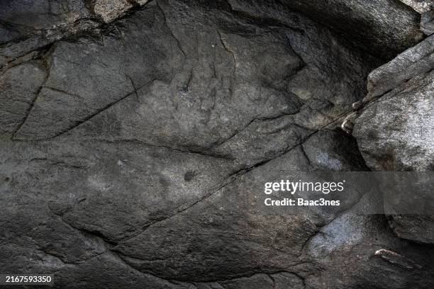 close-up of black rock with cracks - livello di superficie foto e immagini stock