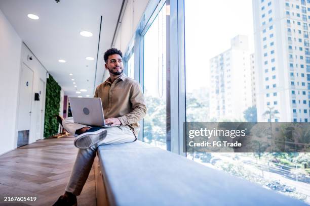 young businessman contemplating at coworking - college student thinking stock pictures, royalty-free photos & images