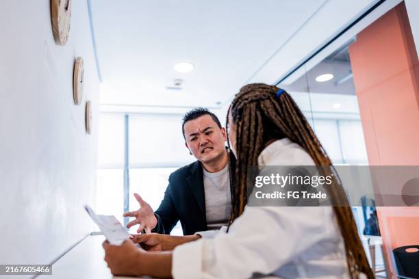 mid adult leader man complaining to employee at office - rudeness stock pictures, royalty-free photos & images