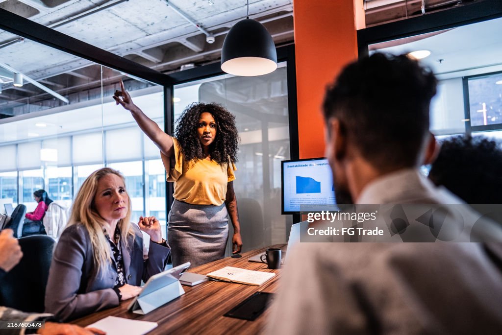 Mid adult leader woman scolding employee during meeting at office