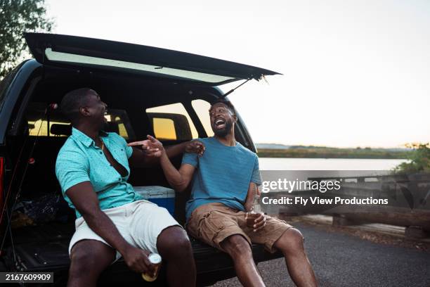 male best friends laughing together after fun fishing trip - tail gate stock pictures, royalty-free photos & images