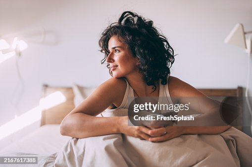 Relaxed Woman Enjoying Morning Coffee in Cozy Bedroom Relaxed Woman Enjoying Morning Coffee in Cozy Bedroom